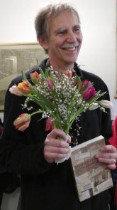 Per Ambrosiani med blommor och hyllningsskriften i handen